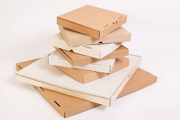 Farklı boyutlarda ve renkli pizza kutuları. Bir yığın pizza kutusu. - Fotoğraf, Görsel