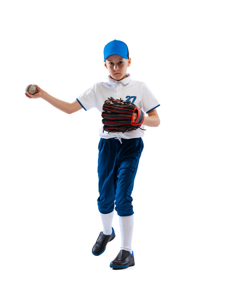 Little boy, baseball player, pitcher in blue-white uniform training isolated on white studio background. Concept of sport, achievements, studying, competition. Copy space for ad - Zdjęcie, obraz