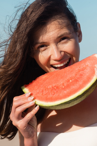 glückliche junge Frau isst im Sommer geschnittene und saftige Wassermelone - Foto, Bild