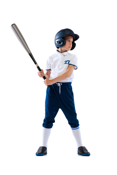To bat. Little boy, baseball player, pitcher in blue-white uniform training isolated on white studio background. Concept of sport, achievements, studying, competition, childhood. Copy space for ad - Foto, Imagem