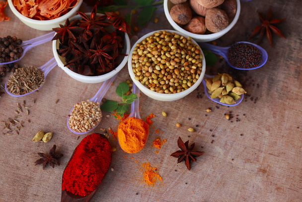 Колір трав і спецій для приготування їжі, індійські спеції, індіанські спеції на дерев'яному столі, індіанська кухня. Верхній вид плоский, індійський листя затоки, Гарам масала, Mace, Javitri, Nutmeg, Jaiphal, Star Anise, - Фото, зображення