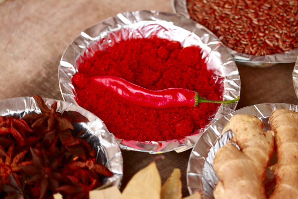 Erilaisia mausteita ja yrttejä pöydällä, tumma ja valkoinen pöytä värikkäitä mausteita, perinteinen aasialainen mauste valkoisessa kulhossa, intialaiset mausteet - Valokuva, kuva
