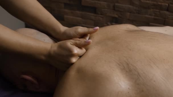 Ręce profesjonalnego masażysty szyi męskiego klienta, rozpieszczający, dobre samopoczucie, zbliżenie. Nierozpoznawalny mężczyzna otrzymuje masaż w spa, relaksujące wakacje, wellness resort, przyjemność - Materiał filmowy, wideo