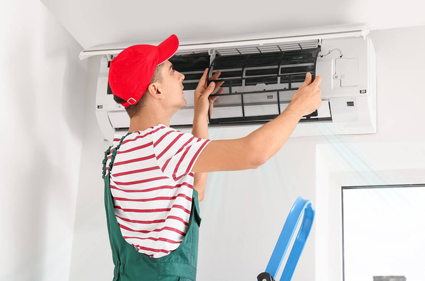 mannelijke technicus repareert airconditioner   - Foto, afbeelding