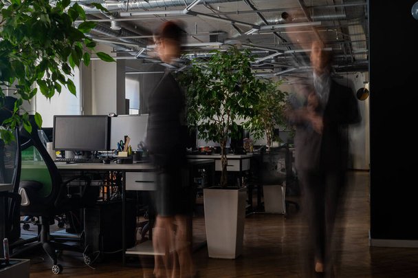 Blurred female figures in motion in the office - Foto, Imagen