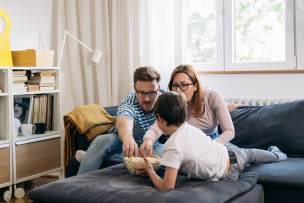 family eating popcorn and enjoying time at home - Foto, Bild