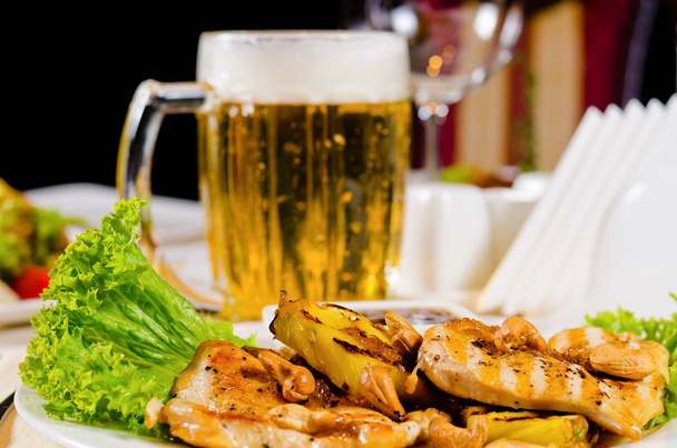 Plato de pollo anacardo de piña con taza de cerveza
 - Foto, imagen