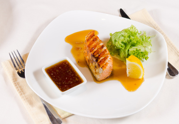 Plat de saumon grillé avec sauce et garniture
 - Photo, image