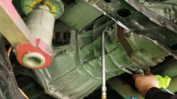 Autopflege: Mechaniker repariert Diesel-Pick-up-Getriebe nach Fahrleistung, indem er die Getriebeflüssigkeit wechselt und die Kompression der Schrauben überprüft. - Filmmaterial, Video