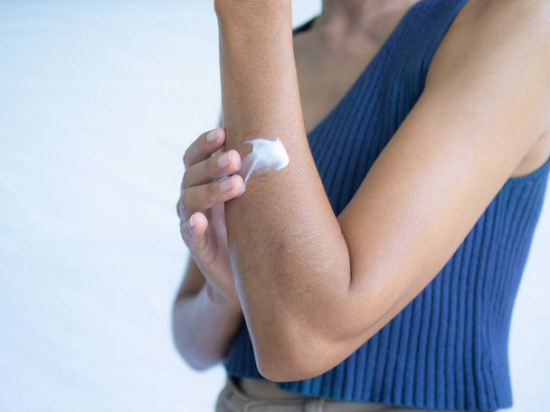 Κοντινό πλάνο γυναίκα εφαρμογή κρέμα στο χέρι. αυθεντικό μαύρισμα δέρματος ασιατική Ταϊλάνδη. καλλυντική ενυδατική λοσιόν σώματος περιποίησης δέρματος για απαλή και ενυδατωμένη επιδερμίδα και αντηλιακή προστασία UV έννοια. - Φωτογραφία, εικόνα