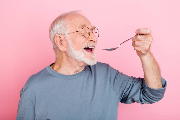 Photo of dreamy sweet retired man grey sweater spectacles eating tasty dish isolated pink color background. - Фото, зображення