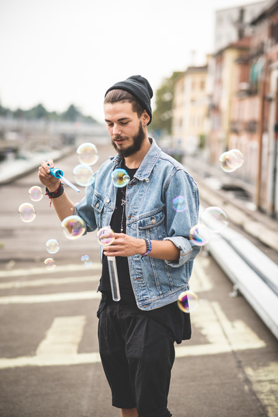 genç yakışıklı baloncuklar sabun üfleme hipster adam sakallı - Fotoğraf, Görsel
