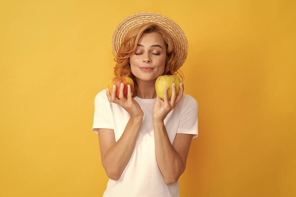 天然の有機新鮮なリンゴです。健康的な生活。食事と肌の美しさ。歯のケア。昼休みだ。デトックス。アップルフルーツで笑顔の女の子。ビタミンと食事。藁帽子の女性は健康的な食べ物を食べ. - 写真・画像