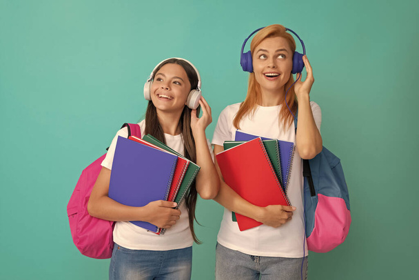 İlham verici okul öğrencisi ve kulaklıklı öğrenci ellerinde çalışma kitapları ve sırt çantası, müzik.. - Fotoğraf, Görsel