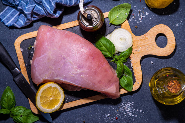 Raw turkey breast filet with spices for cooking. Turkey breast white meat cooking background copy space top view - Fotografie, Obrázek