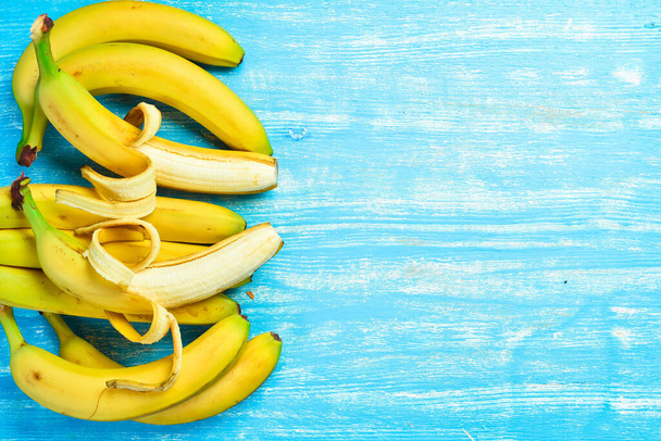 Set of fresh raw bananas on a blue wooden background. Top view. - Фото, зображення