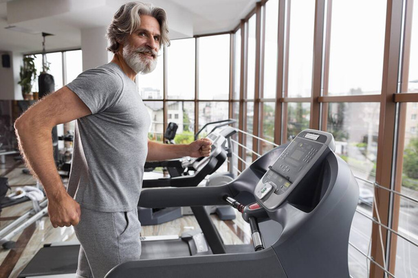 side view man running treadmill. High resolution photo - Photo, Image