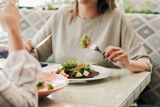 Close Up of Unrecognisable Women Having Lunch Meeting, Eating Salad in Restaurant - Foto, afbeelding