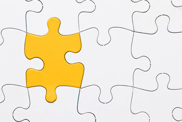 overhead view yellow puzzle among white piece. High resolution photo - Photo, Image