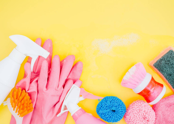 spray bottle brush sponge pink gloves yellow backdrop. High resolution photo - Фото, изображение