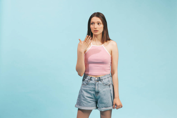 Amaze, wonder. Portrait of emotional girl wearing top and denim shorts posing isolated on blue background. Concept of emotions, facial expression, youth, aspiration, sales - Foto, Bild
