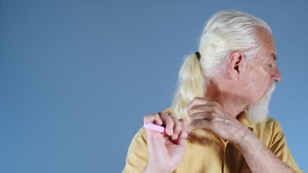 Az öregember fésüli a fehér haját. - Felvétel, videó