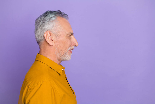 Profile photo of funny aged grey hairdo man look empty space wear mustard shirt isolated on violet color background. - Foto, immagini