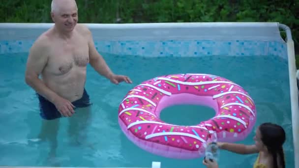 grandfather and granddaughter swimming in the pool. - Footage, Video