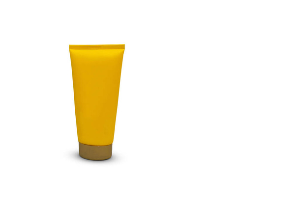 Embalaje de tubo amarillo para protector solar, crema cosmética y corporal aislada sobre fondo blanco. Tubo humectante sin marca. - Foto, imagen