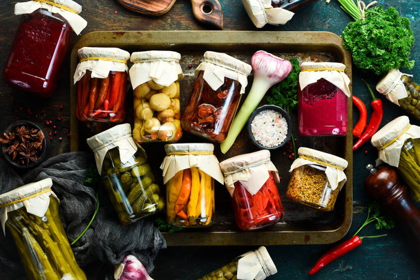 Homemade pickled vegetables in a glass jar. Food supplies. On a stone background. Top view. - Photo, image