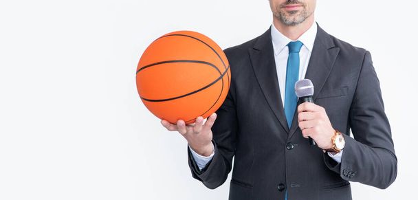 Takım elbiseli olgun bir adam basketbol topunu tutuyor ve Mike beyaz arka planda izole edilmiş.. - Fotoğraf, Görsel