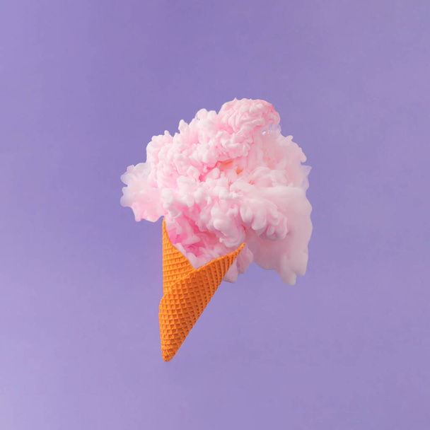 Orange ice cream cone with pastel pink color paint against purple background. Minimal abstract summer concept.  Creative sweet food surreal composition. - Fotografie, Obrázek