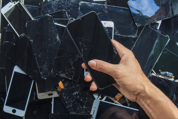 Smartfony i ekrany telefoniczne uszkodzone w wyniku użytkowania są zbierane w celu recyklingu cennych minerałów, ponieważ e-odpady zawierają cenne minerały w urządzeniu i muszą być ekstrahowane - Zdjęcie, obraz