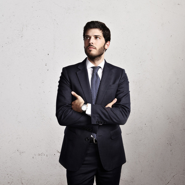 Businessman on bright concrete background - Foto, Imagen