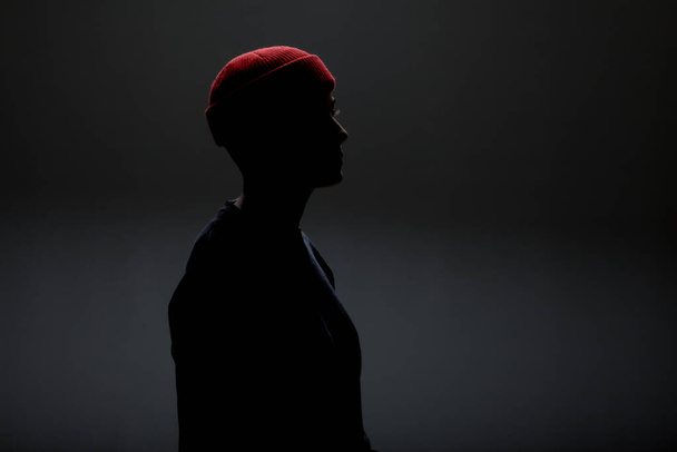 Girl with short hair wearing blouse and red hat against gray background. - Φωτογραφία, εικόνα