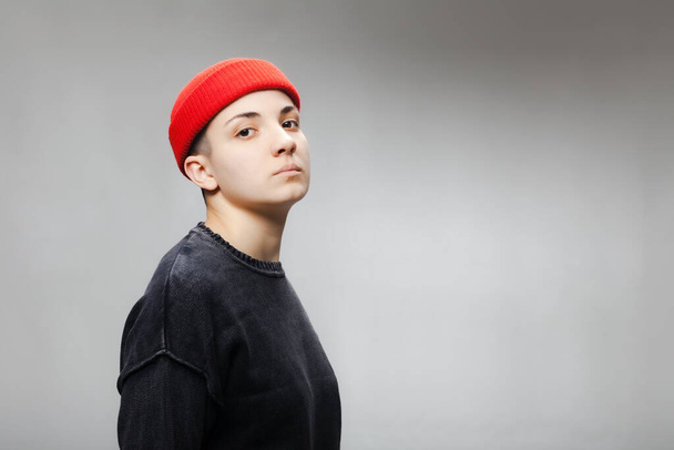 Girl with short hair wearing blouse and red hat against gray background. - Fotografie, Obrázek