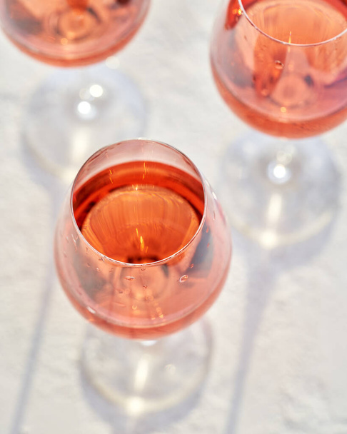 Bicchieri di vino rosato su sfondo brillante - Foto, immagini