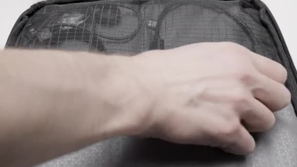Detailní záběr mužské ruky otevírá zámek na zip síťované kapsy. Akce. Batoh s nabíjecími dráty - Záběry, video