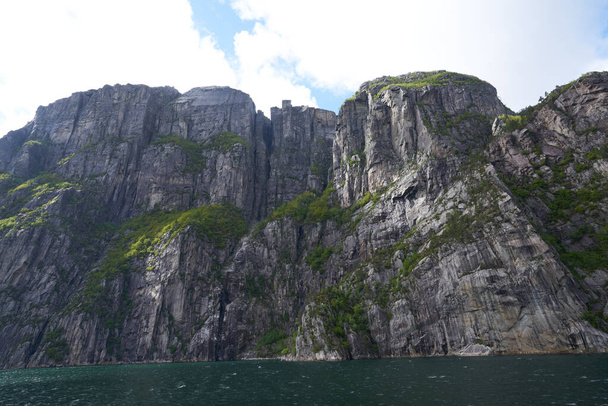 Skała z ambony Preikestolen z granitu widziana z dołu fiordu i kanionu Lysefjord w Norwegii - Zdjęcie, obraz