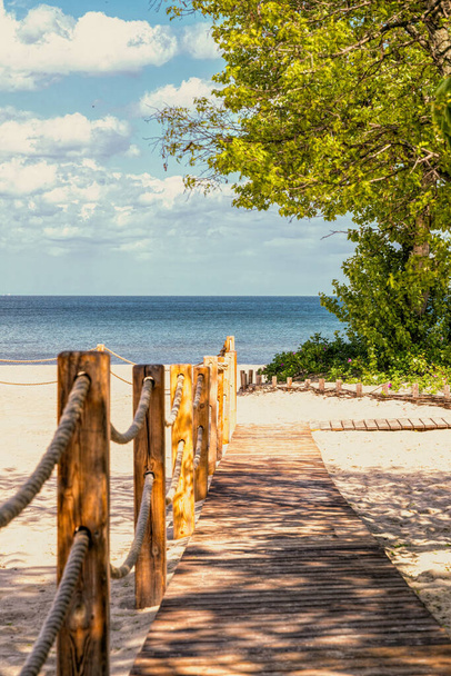 Passerelle en bois sur une plage de sable ensoleillée - Photo, image