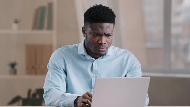 Wściekły facet irytujący Afrykański Amerykanin mężczyzna szef pracownik niezadowolony ma problem z pracą systemu komputerowego czuje gniew agresja z nieudanych transakcji biznesowych powolny internet czytać złe wiadomości utraty danych - Materiał filmowy, wideo
