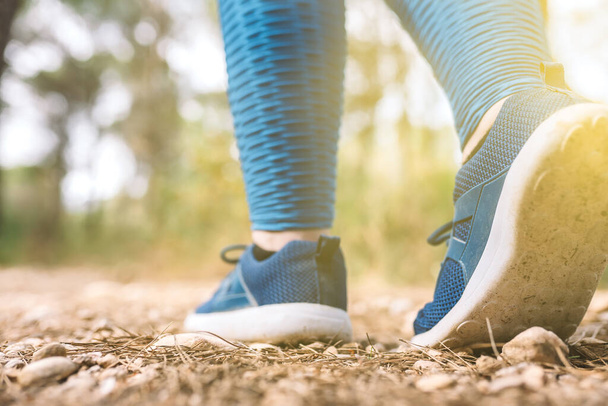 detail of a womans trainers. woman athlete playing sport outdoors. concept of wellbeing and healthy living. outdoors, natural sunlight. - Photo, Image