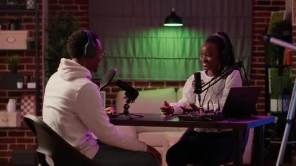 Αφροαμερικανή δημιουργός περιεχομένου γυναίκα ηχογράφηση podcast με διασημότητα τραγουδίστρια στο στούντιο σπίτι. Online ραδιοφωνικός παρουσιαστής μιλώντας σε συνέντευξη με τον influencer για ψυχαγωγία internet show αργά το βράδυ. - Πλάνα, βίντεο