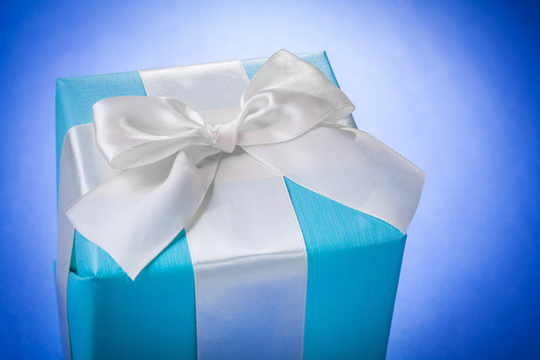 blue giftbox with white ribbon on blue background - Photo, Image