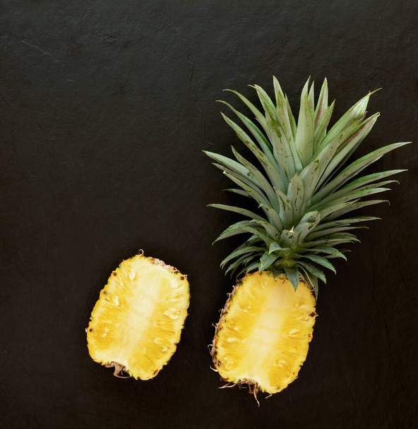 pineapple on the black texture background. .have a lot of fiber,vitamins C and minerals. food, fruits or healthcare concept. - Fotografie, Obrázek