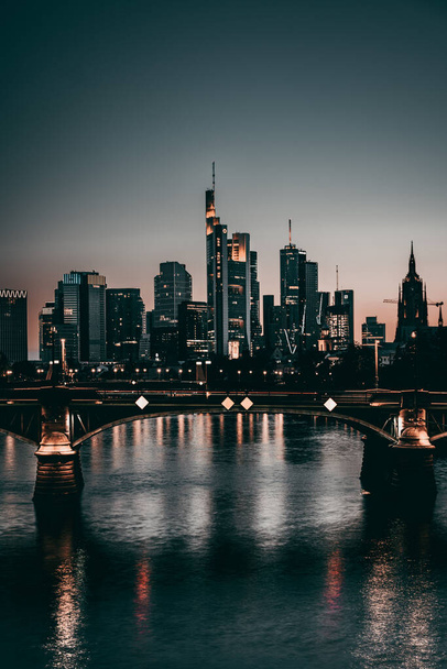 A beautiful shot of Frankfurt skyline with Ignatz-Bubis bridge over Main river and Commerzbank at night - Photo, Image