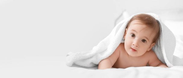 Portret van schattige baby jongen onder handdoek op lichte achtergrond met ruimte voor tekst - Foto, afbeelding