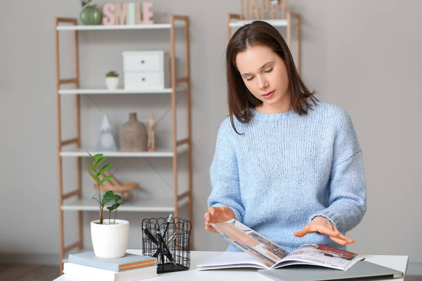 Pretty young woman reading magazine at home - Foto, immagini