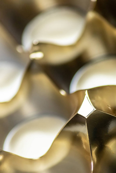 Abstrait motif de fond doré macro gros plan de surface métallique argentée et dorée avec des reflets brillants et des formes harmoniques avec des cercles et des cônes élégant design futuriste graphiques ondes métalliques - Photo, image