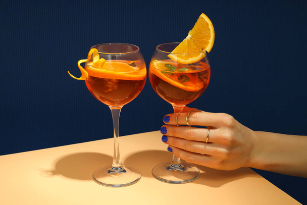 Έννοια του καλοκαιρινού αλκοολούχου ποτού, γυναικείο χέρι κατέχει Aperol Spritz - Φωτογραφία, εικόνα